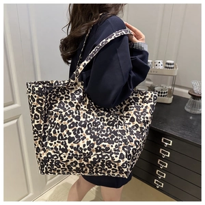 Close-up of leopard print tote bag featuring a large functional exterior front pocket