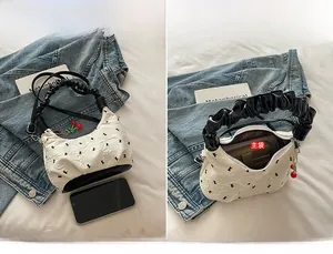 Dettaglio della borsa color crema con trama a bolle e spazio interno del compartimento principale