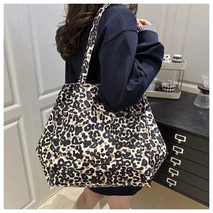 Detail of large leopard print canvas tote bag with front pocket and shoulder strap
