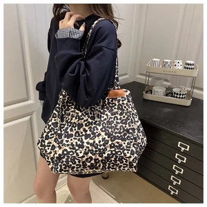 Detail view of large leopard print tote bag with double straps worn over the shoulder