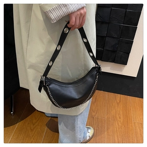 Close-up of black leather hobo bag with silver chain detail and metallic eyelets strap