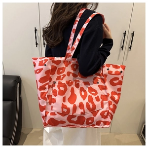 Close-up of pink leopard print tote bag with large front pocket and red animal patterns