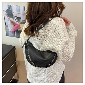 Detail of black matte leather hobo bag with metal chain and adjustable eyelet strap