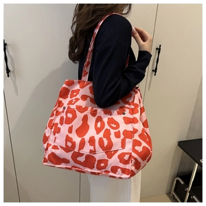 Detail of pink leopard tote bag showing the front pocket with dual metal snap buttons