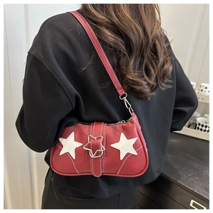 Detail of red leather shoulder bag with white star patches and metal star buckle