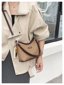 Detail of vintage canvas crossbody bag with leather strap and wooden bead accessory