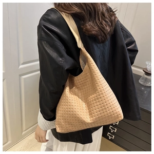 Detailed close-up of woven leather texture on a beige large capacity hobo tote bag