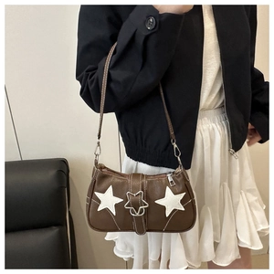 Close-up of brown faux leather shoulder bag featuring star patches and star metal clasp