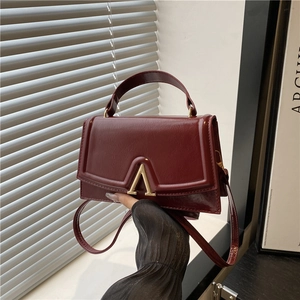Deep burgundy glossy PU leather handbag with elegant gold V-buckle and top handle