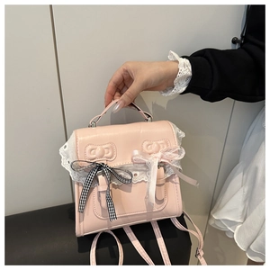 Close-up of pink lace bow decoration and embossed leather details on square flap bag