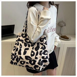 Detail of leopard print tote bag featuring a snap front pocket and canvas texture
