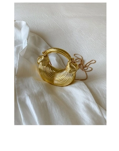 Detail of gold metallic pleats and chain strap on a designer box bag for women