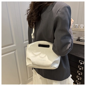 Close-up of white glossy chain handbag with oval cutout handle and fashion lettering