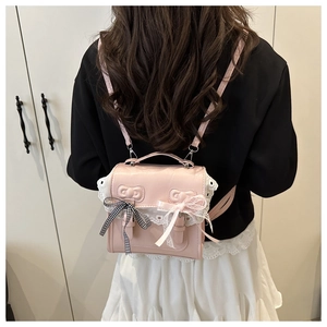 Detail of pink PU leather mini backpack with lace embroidery and decorative bows
