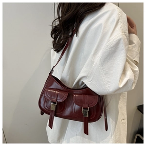 Model wearing dark red retro underarm bag with silver buckles and dual pockets details