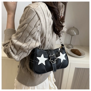 Close-up of black lychee grain shoulder bag with star buckle and star patterns