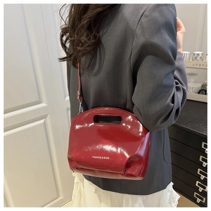 Detail of glossy wine red patent leather bucket bag with white Fashion & Bags text