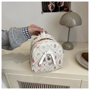 Detail of floral mini backpack with quilted pattern, ribbon bow and heart pendant