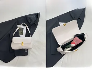 Detail view of the interior capacity and lock design of the cream small square bag