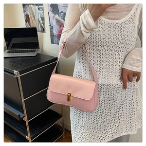 Detail of soft pink leather handbag with elegant gold clasp and adjustable shoulder strap