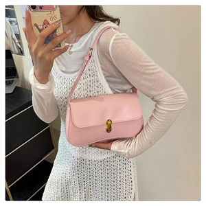 Detail of pink PU leather shoulder bag with a gold oval twist lock closure