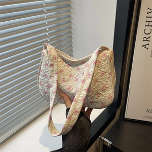 Fresh white quilted shoulder bag with pink bow patterns in soft natural sunlight