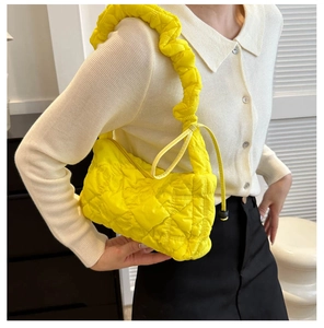 Détail d'un sac à bandoulière matelassé jaune vif avec bandoulière froncée