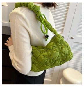 Detail of vibrant green quilted ruched hobo bag featuring adjustable drawstring shoulder strap