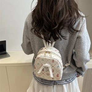Mini white backpack with cute rabbit and strawberry prints, shown on a model's back