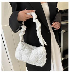 Detailed view of white quilted shoulder bag with scrunchie handle and textured pattern