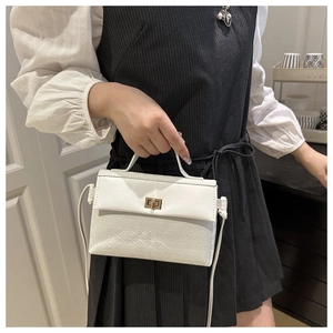 Detail of white leather shoulder bag with textured monogram and golden swivel lock