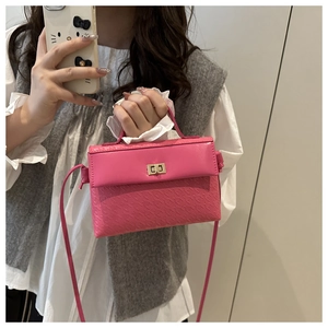 Detailed view of pink textured crossbody bag with gold rotary lock and handle