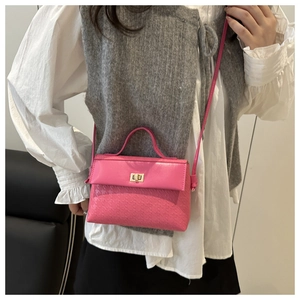Detailed view of rose pink trapezoid handbag with textured pattern and metal buckle