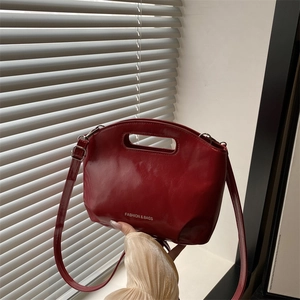 Minimalist red glossy bucket bag with top handle and shoulder strap for women