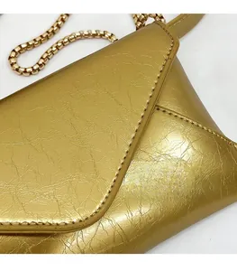 Detailed macro of golden wrinkled leather handbag edge with precise stitching and chain
