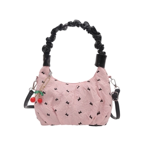 Pink quilted dumpling bag with black bows, cherry pendant, and crossbody strap