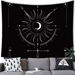 Detail of bohemian sun and moon tapestry hanging above a grey sofa with decorative pillows