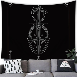 Bohemian black tapestry with white celestial sun and moon motifs hanging above a modern sofa