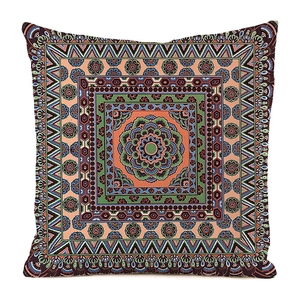 Detail of bohemian mandala pattern with orange and blue hues on silk-like pillow cover