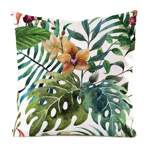 Detailed close-up of tropical palm leaves and orchid floral print on silk cushion cover