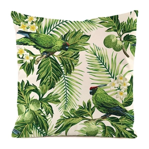 Detail of tropical throw pillow case with green parrots and botanical palm leaf patterns