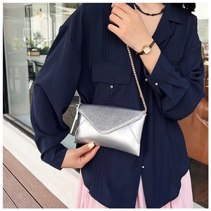 Silver envelope clutch bag with metallic crinkle finish and elegant gold chain strap