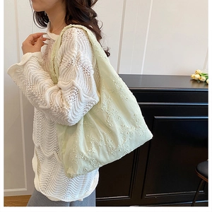 Détail du sac cabas vert clair avec broderie florale et texture en lin et coton