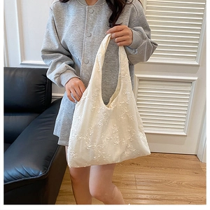 Détail du sac cabas en dentelle blanche avec broderies florales élégantes pour femme