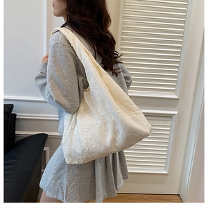 Détail rapproché de la broderie florale sur ce grand sac cabas en toile pour femme