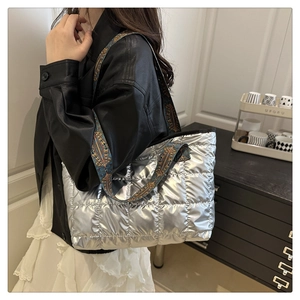 Détail du sac cabas matelassé argenté avec une large bandoulière colorée de style ethnique