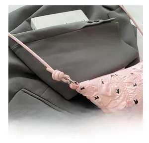 Detail showing pink pleated fabric texture with black dots and metal ring buckle