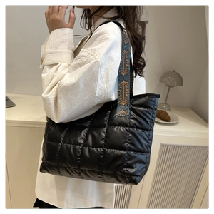 Detailaufnahme der schwarzen Stepptasche mit buntem Jacquard-Schultergurt im Ethno-Stil