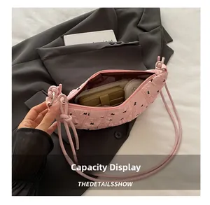 Macro view of spacious interior in pink pleated dumpling bag with daily essentials