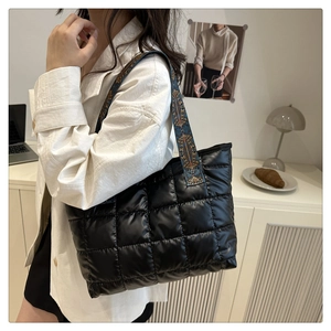 Détail du sac fourre-tout noir matelassé avec bandoulière décorative en jacquard